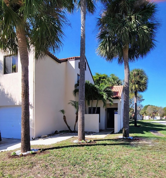 view of side of home featuring a yard and a garage