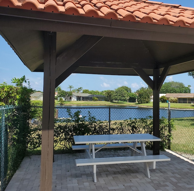 surrounding community featuring a water view, a gazebo, and a patio