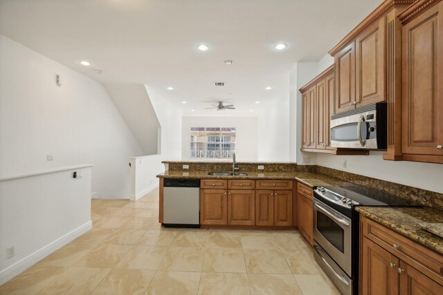 kitchen with sink, stainless steel appliances, dark stone counters, and washer / clothes dryer