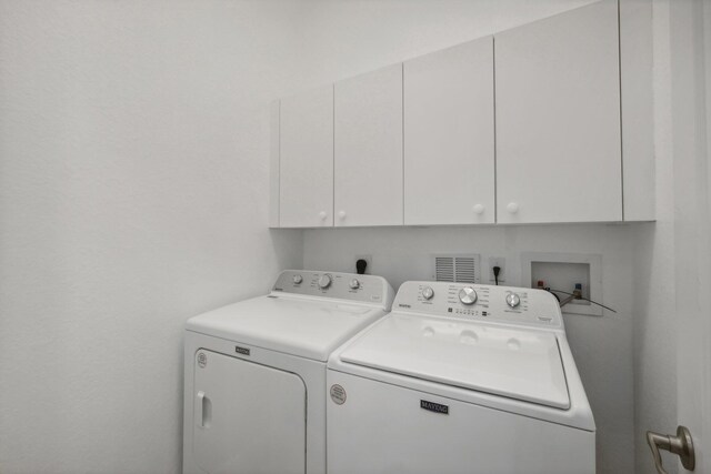 kitchen featuring washer / dryer, kitchen peninsula, stainless steel appliances, light tile patterned flooring, and stone countertops