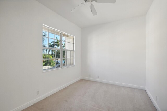 unfurnished bedroom with ceiling fan, light colored carpet, and multiple closets