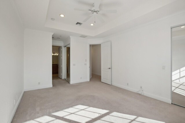 carpeted bedroom with ceiling fan and a tray ceiling