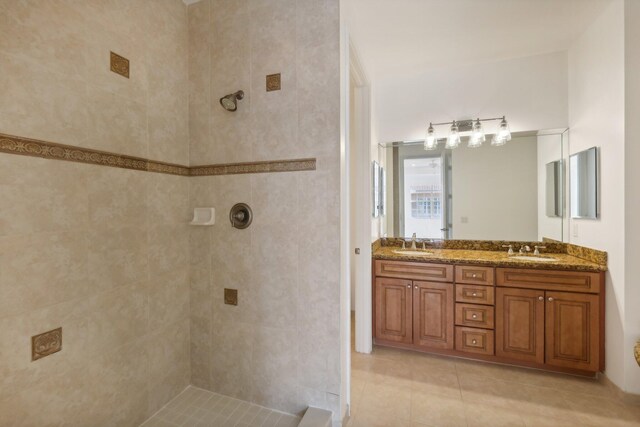 bathroom with tiled tub, tile patterned floors, and vanity