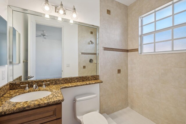 unfurnished bedroom featuring ceiling fan, light colored carpet, and ensuite bathroom