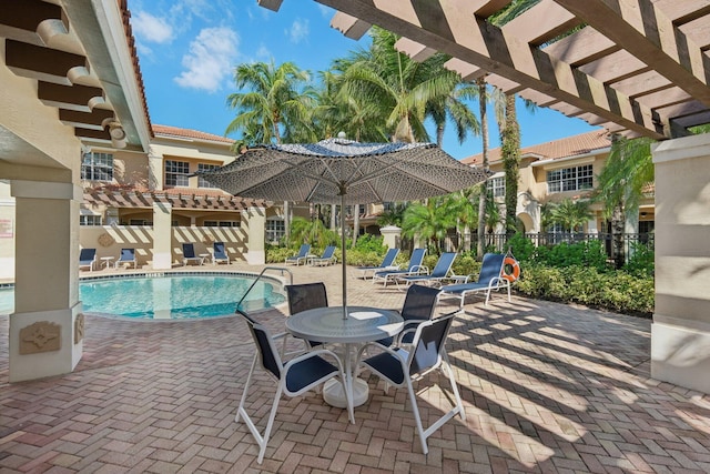 view of patio with a community pool and a pergola