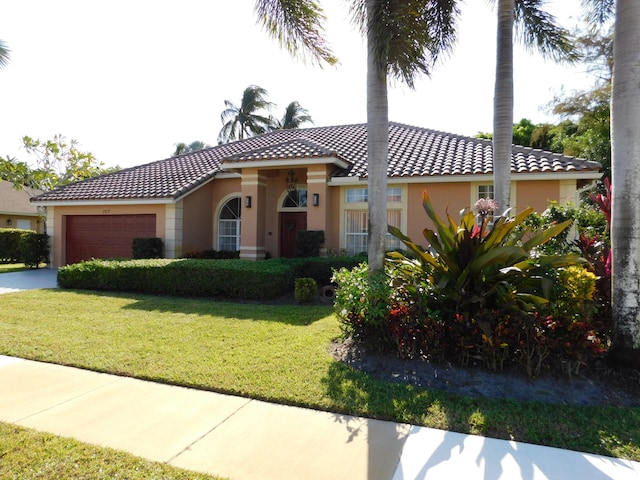 mediterranean / spanish-style home with a front yard and a garage