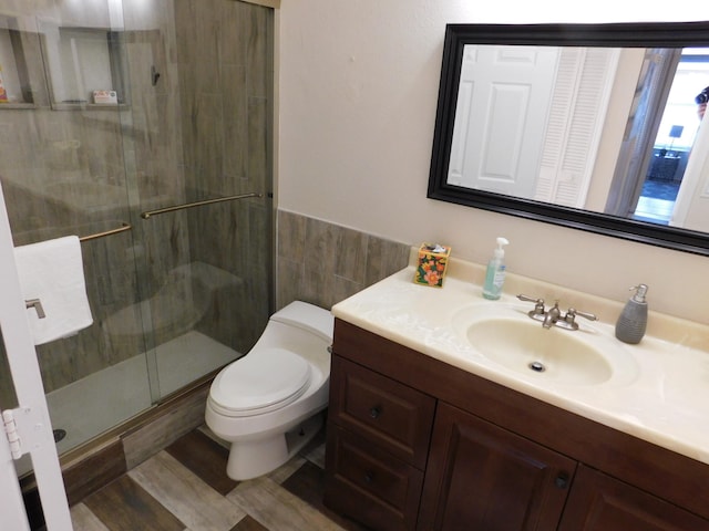 bathroom featuring vanity, toilet, tile walls, and an enclosed shower