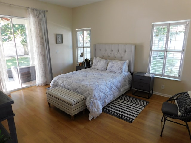 bedroom featuring light hardwood / wood-style flooring, multiple windows, and access to exterior