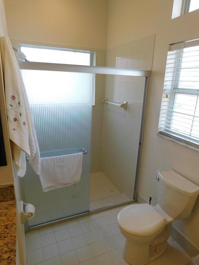 bathroom with toilet, walk in shower, and tile patterned flooring