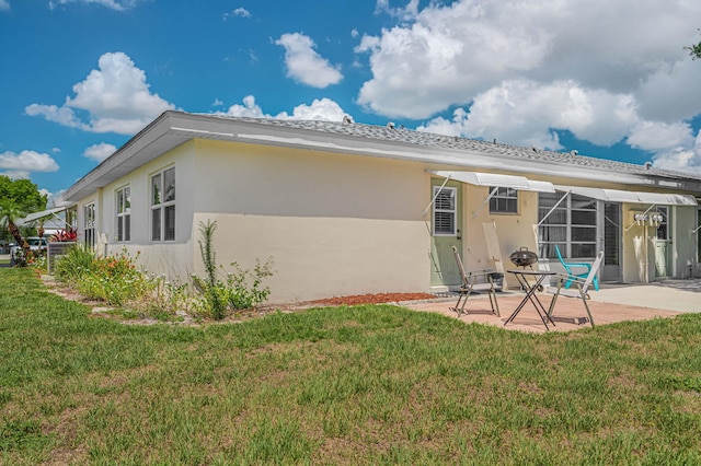 rear view of house with a yard and a patio