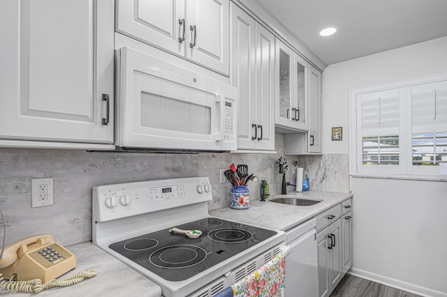 kitchen with decorative backsplash, white appliances, and sink