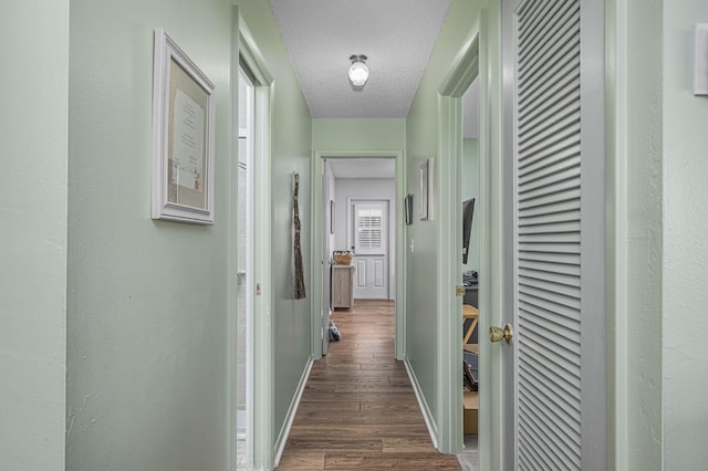 hall featuring dark hardwood / wood-style flooring and a textured ceiling