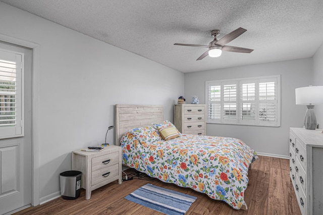 bedroom featuring multiple windows, ceiling fan, dark wood-type flooring, and a textured ceiling