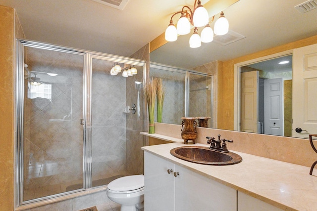 bathroom with a shower with door, toilet, tile patterned floors, vanity, and an inviting chandelier