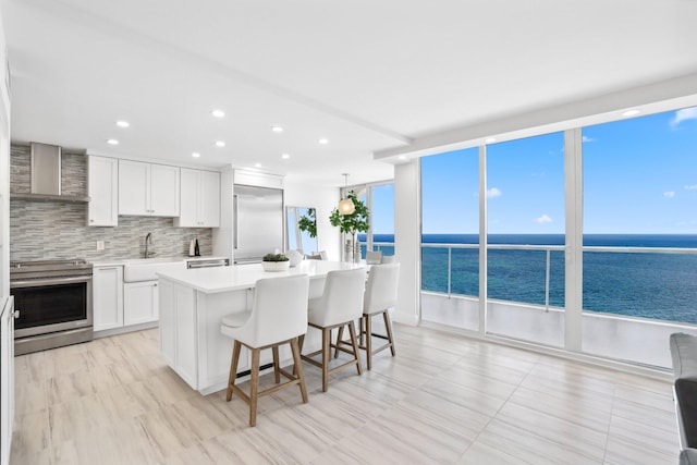 kitchen featuring a water view, a center island, stainless steel range with electric cooktop, and backsplash