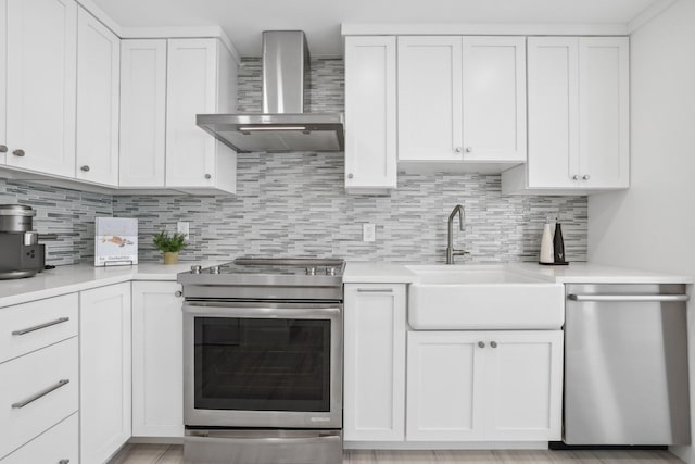 kitchen with white cabinetry, wall chimney range hood, and stainless steel appliances