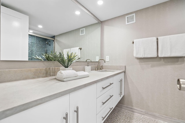 bathroom with walk in shower and vanity