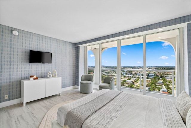 bedroom with light hardwood / wood-style floors and multiple windows