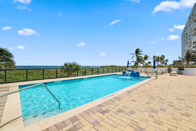 view of swimming pool with pool water feature and a patio area