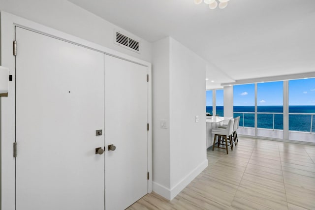 hall featuring expansive windows and a water view