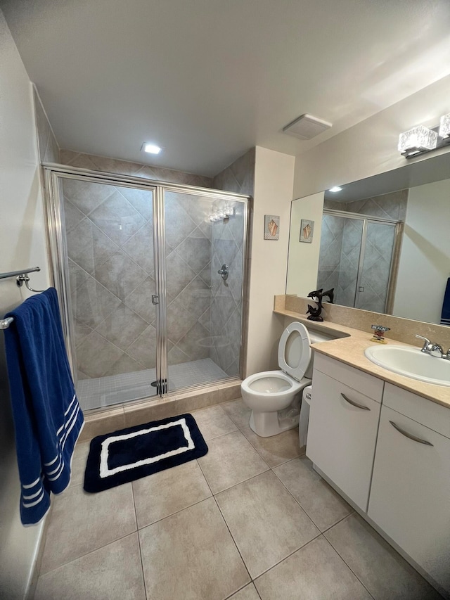 bathroom featuring toilet, tile patterned flooring, vanity, and a shower with door