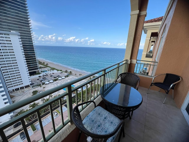 balcony with a water view and a view of the beach