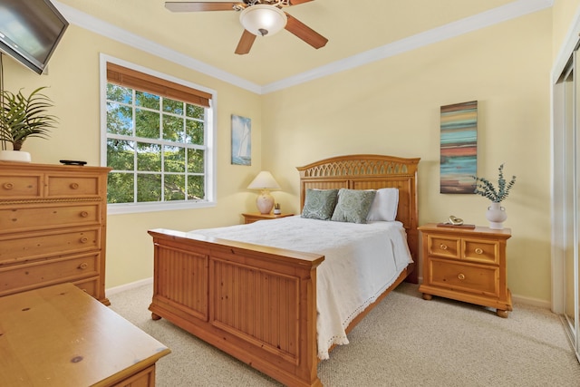 carpeted bedroom featuring ceiling fan and crown molding