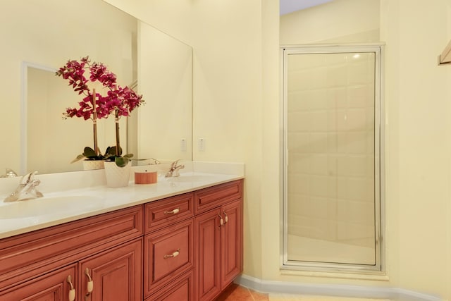 bathroom with an enclosed shower, vanity, and tile patterned flooring