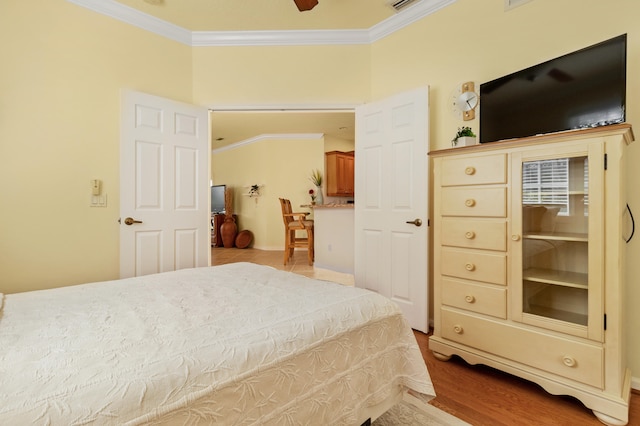 bedroom featuring ceiling fan, light wood-type flooring, and ornamental molding