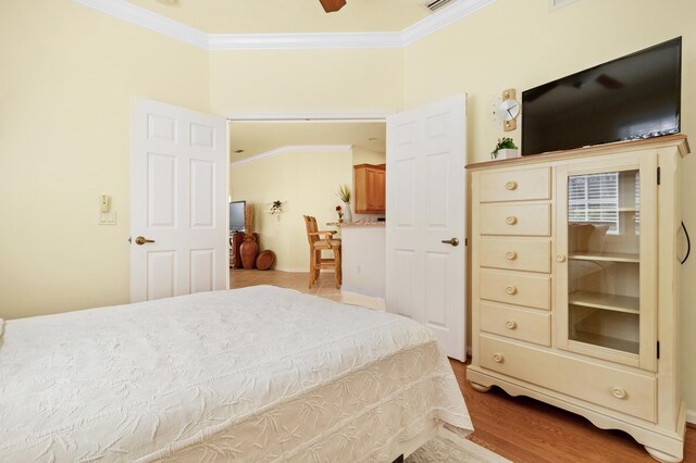 bedroom featuring hardwood / wood-style floors, crown molding, a closet, and ceiling fan