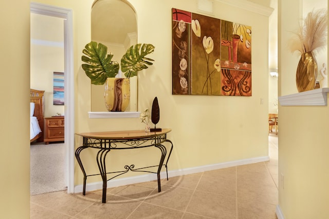 hallway with ornamental molding and tile patterned flooring