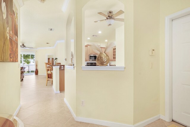 kitchen with stainless steel dishwasher, light tile patterned floors, ceiling fan, and dark stone counters