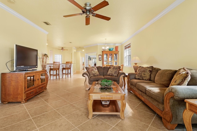 tiled living room with ceiling fan with notable chandelier and ornamental molding