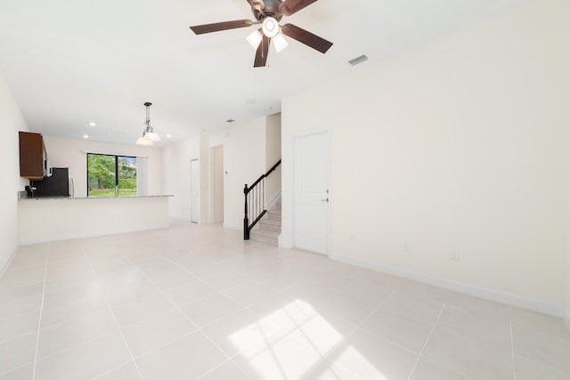 unfurnished living room with light tile patterned floors and ceiling fan