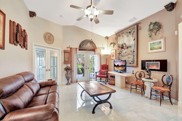 interior space with ceiling fan, french doors, light tile patterned floors, and lofted ceiling