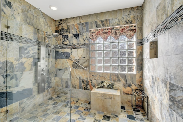 bathroom with a tile shower and tile walls