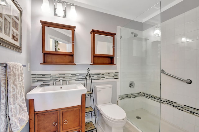 bathroom featuring toilet, a tile shower, tile walls, and vanity