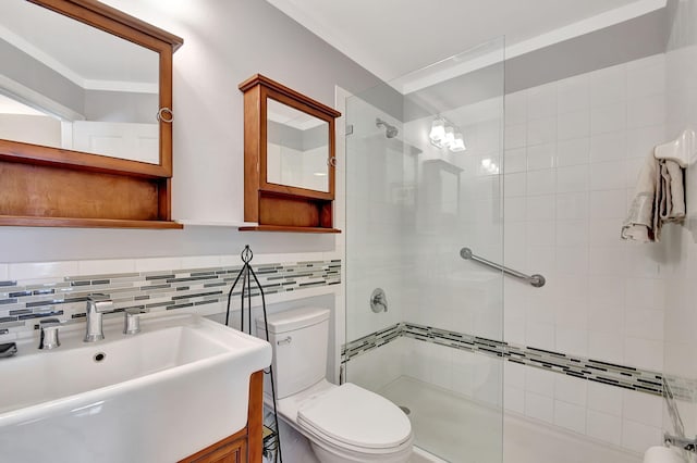 bathroom featuring tiled shower, toilet, decorative backsplash, and sink