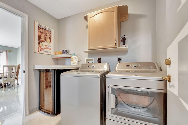 laundry room with cabinets, light tile patterned floors, washer and dryer, and beverage cooler