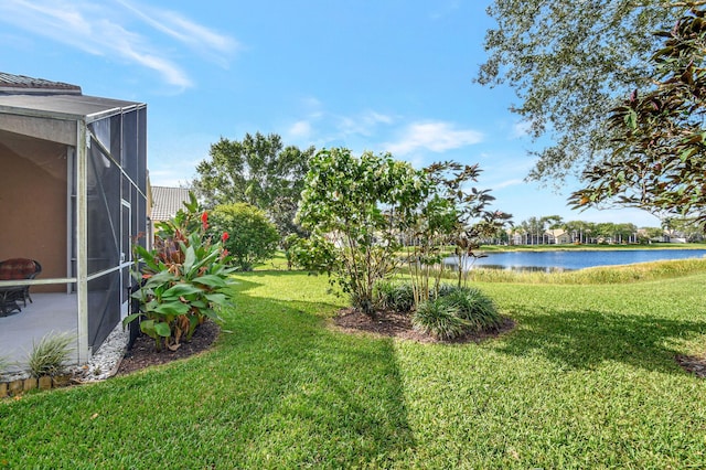 view of yard with a lanai and a water view