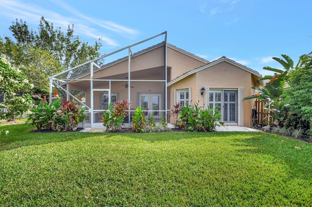 back of property with french doors, a yard, and glass enclosure