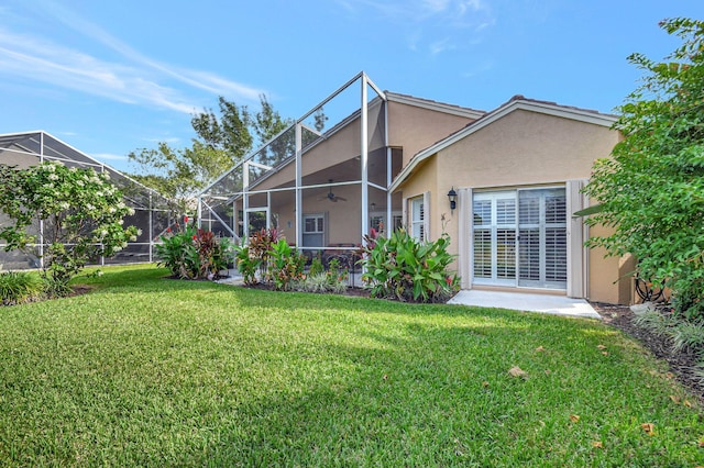 rear view of house featuring a lawn and glass enclosure