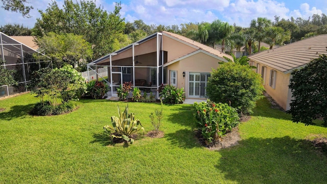 rear view of house featuring glass enclosure and a yard