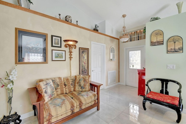 sitting room with light tile patterned floors and high vaulted ceiling