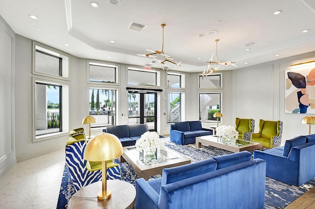 living room featuring a raised ceiling and a notable chandelier