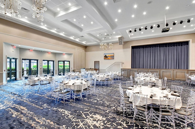 dining room with beamed ceiling, a towering ceiling, coffered ceiling, and an inviting chandelier