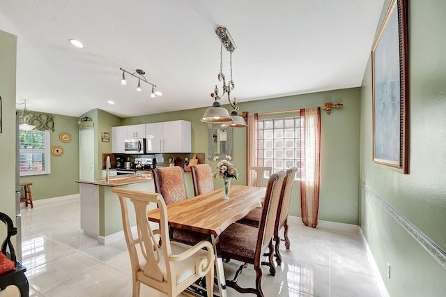 dining space with sink and light tile patterned floors