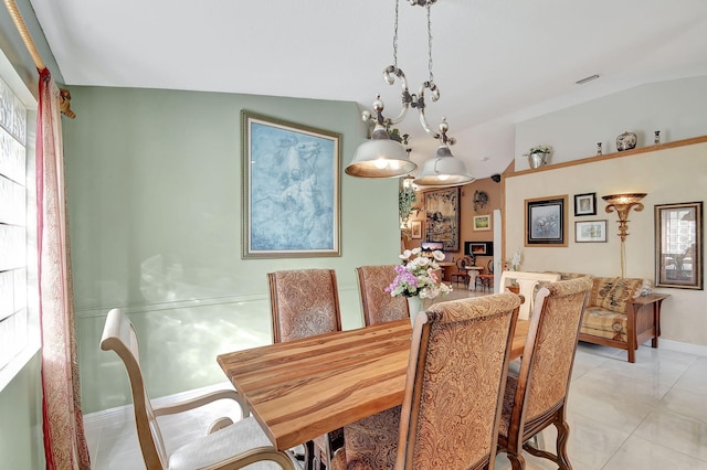 tiled dining room featuring a wealth of natural light, vaulted ceiling, and a notable chandelier