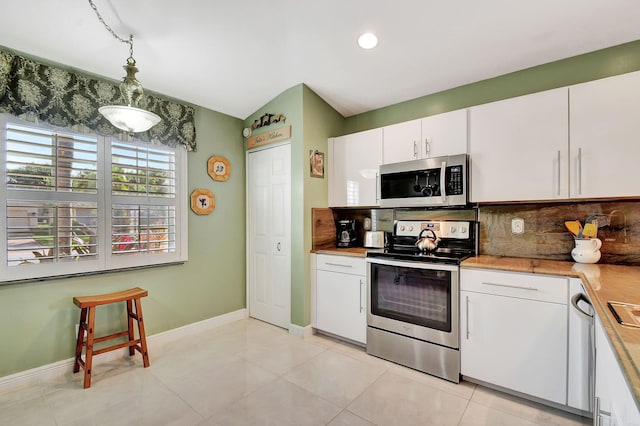 kitchen featuring white cabinets, appliances with stainless steel finishes, backsplash, and light tile patterned flooring