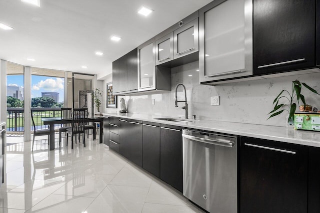 kitchen with stainless steel dishwasher, sink, light stone counters, and backsplash